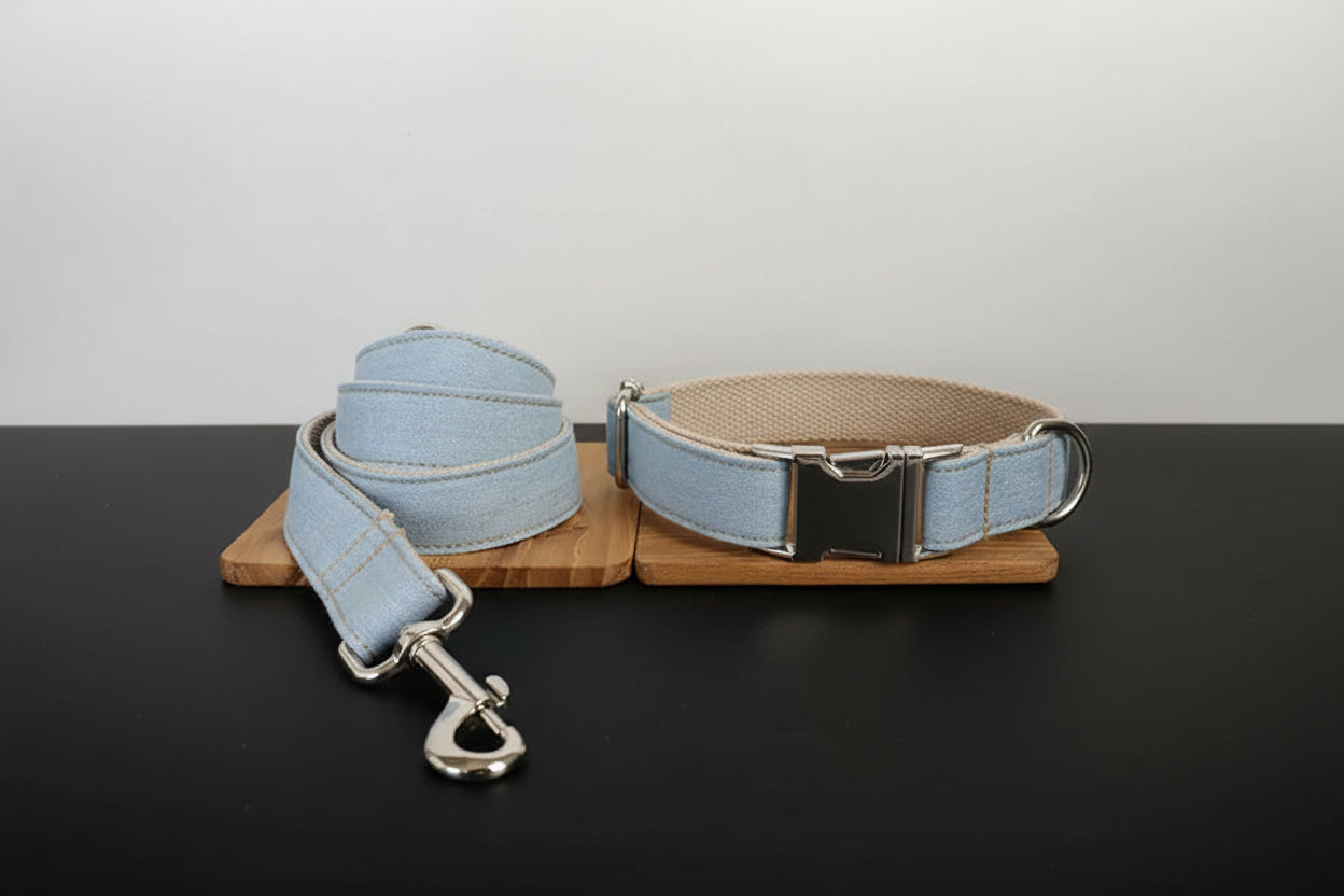 Light blue dog collar and leash set on a wooden stand with a white background